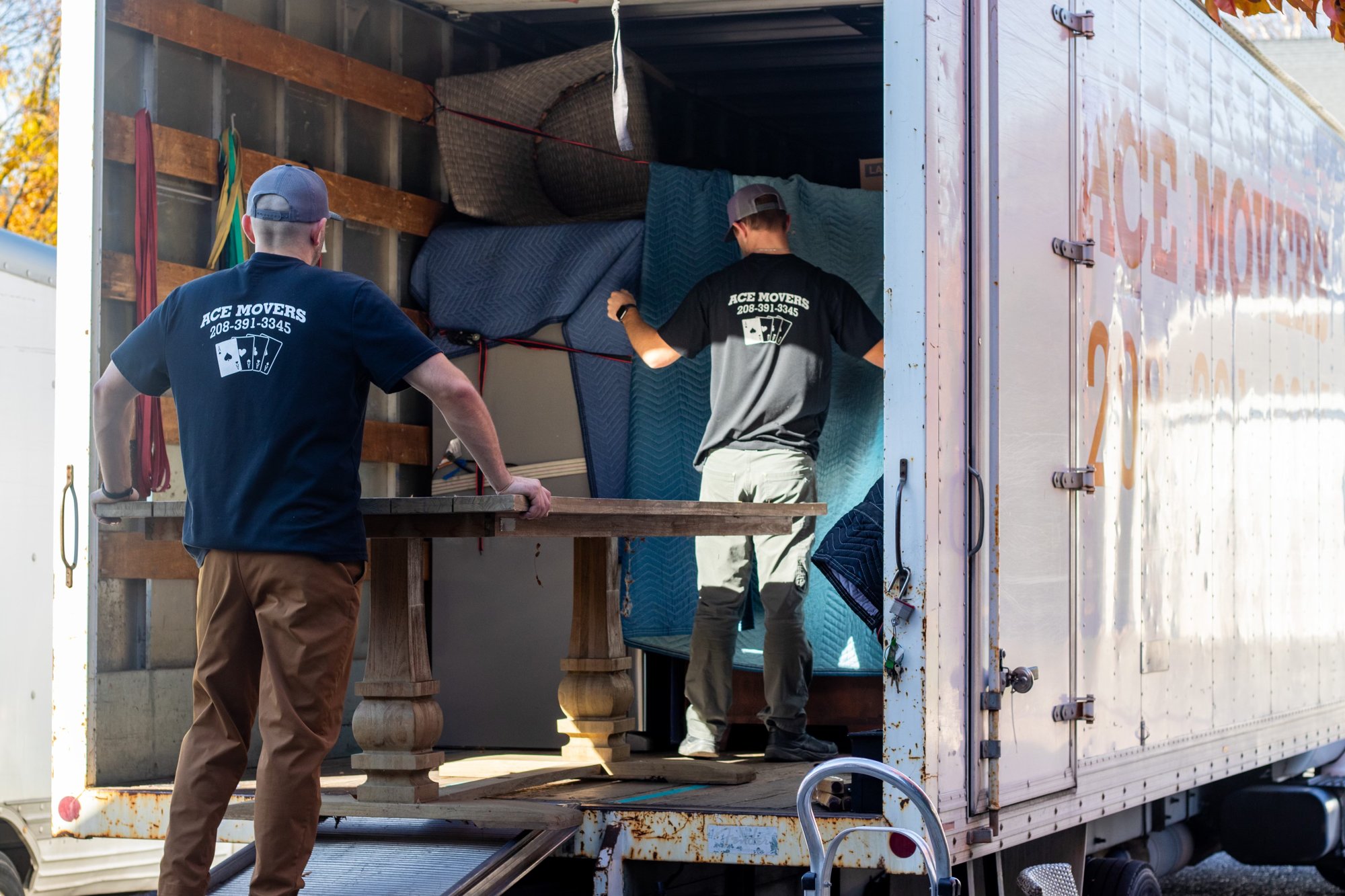 Ace Movers crew loading a large dining table into the truck