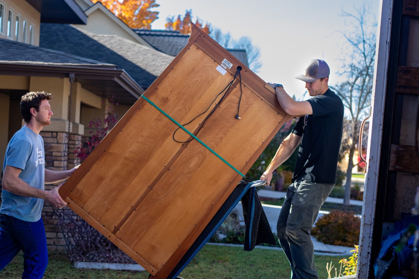 Ace Movers crew carefully moving a wooden dresser